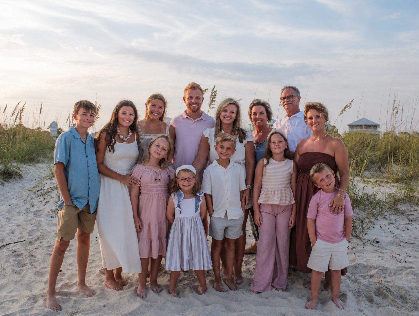 Large family smiling together on the sand near the dunes by Miranda Rae Photography